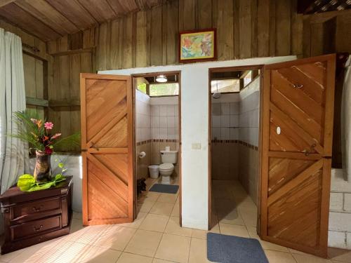 CariariEl Zota Hotel的浴室设有两扇木门和卫生间。