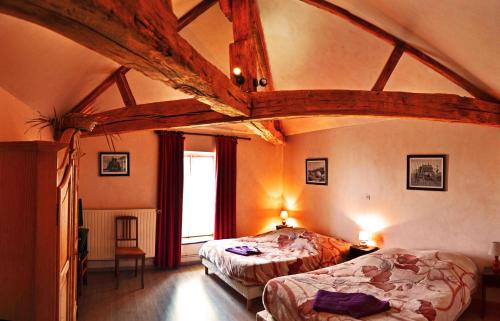 Saint-Paul瑞士三姝农庄旅馆的一间带两张床的卧室,位于一个拥有木制天花板的房间