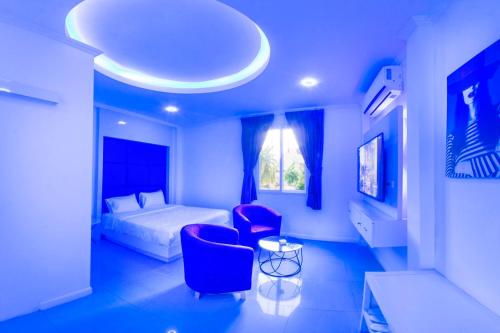 芭堤雅市中心titanic residence的一间卧室配有一张床、两把椅子和一张桌子