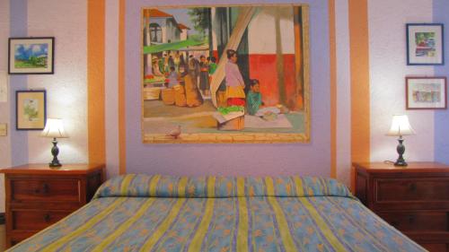 圣帕特里西奥梅拉克La Paloma Oceanfront Retreat的卧室配有一张床,墙上挂有绘画作品