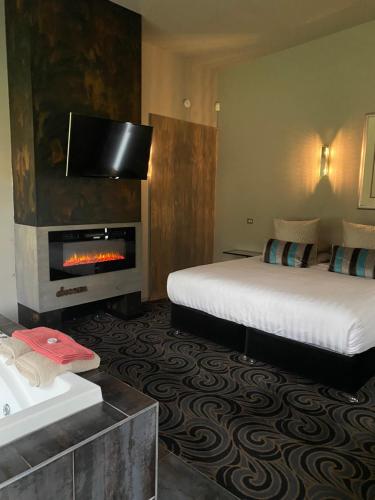 赫本温泉渡鸦Spa套房的酒店客房配有一张床和一个壁炉。