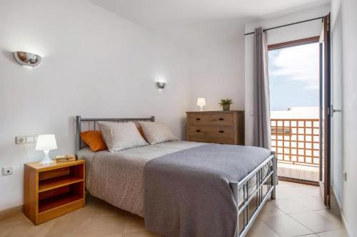 蒂亚斯Modern Duplex in Puerto del Carmen的一间卧室设有一张床和一个大窗户
