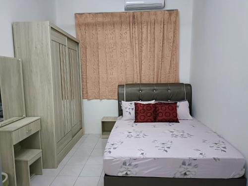 日得拉Adempuri homestay的小卧室配有红色枕头的床