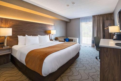 北湾Comfort Inn Lakeshore的酒店客房设有一张大床和一张书桌。