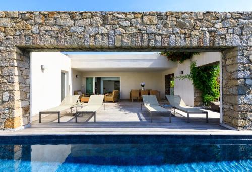 利勒鲁斯VILLA CALA ROSSA的一座带游泳池和石墙的房子