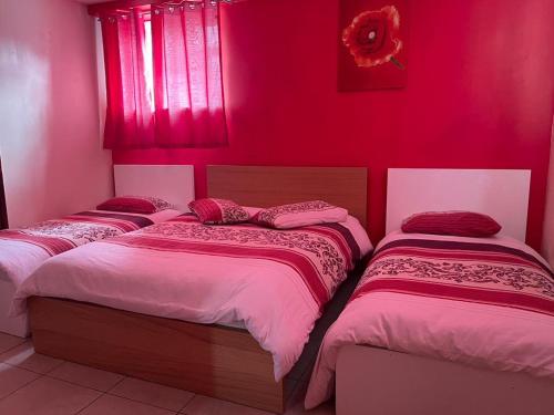 斯劳Nights Inn的红色墙壁的房间里设有三张床
