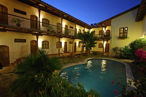 格拉纳达Hotel Patio del Malinche的建筑前带游泳池的庭院
