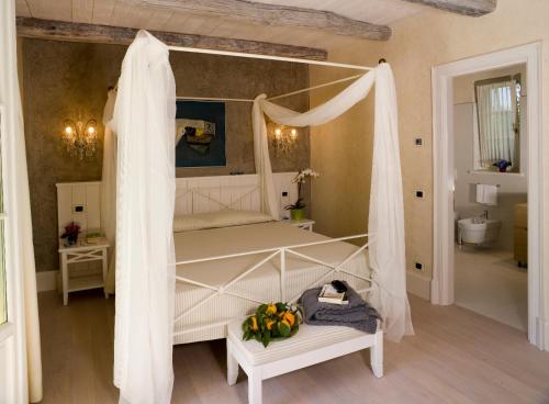 坎诺比奥Park Hotel Villa Belvedere的一间卧室配有一张带天蓬的白色床