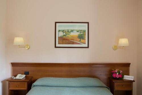 阿尔贝罗贝洛拉玛朋杜拉酒店的卧室配有一张床,墙上挂着一幅画