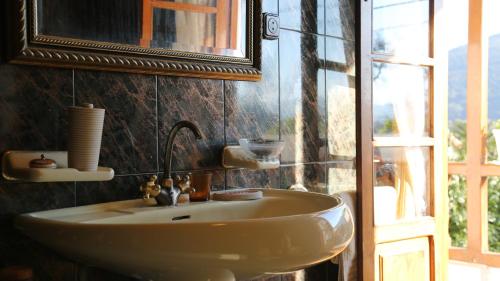 VillanuevaHabitaciones Dobles en Casa的一间带水槽和镜子的浴室以及窗户。