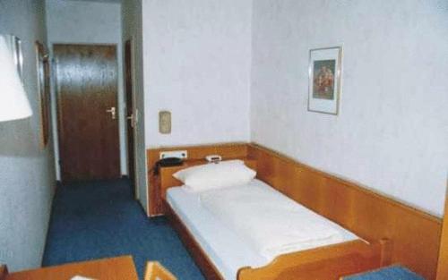 施里斯海姆鲁德威戈斯塔尔酒店的小房间设有一张床和一张桌子