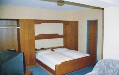 施里斯海姆鲁德威戈斯塔尔酒店的配有木架的床,位于配有电视的房间