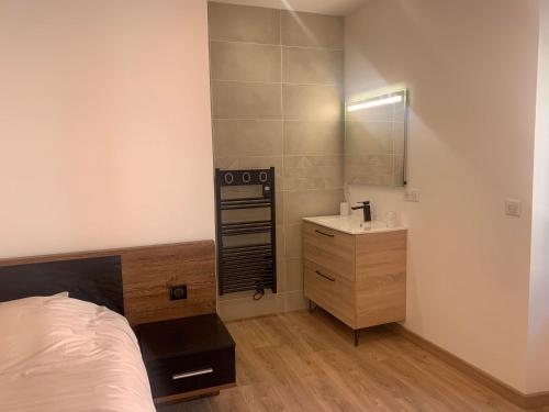 拉马斯特尔Chambre avec entrée indépendante的一间卧室配有床、水槽和镜子