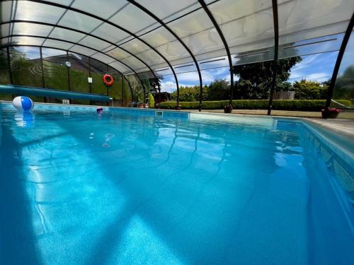 GodshillCypress Log Cabins Accommodation的一座带天蓬的大型游泳池