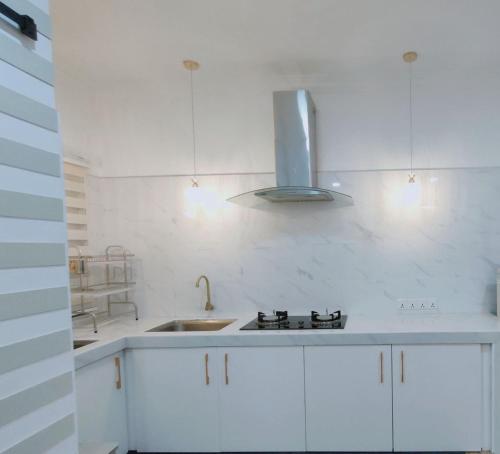 士毛月Spring Fields Homestay by Sizma的白色的厨房设有水槽和炉灶。