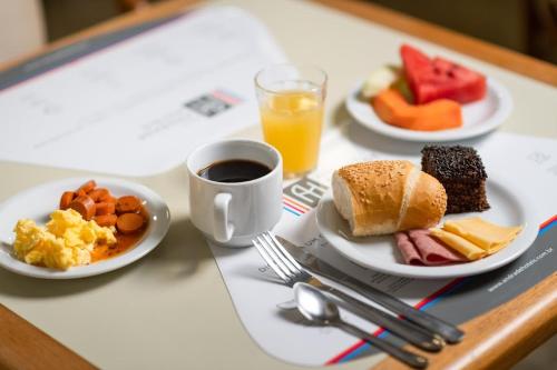累西腓Rede Andrade LG Inn的餐桌,早餐盘和咖啡盘