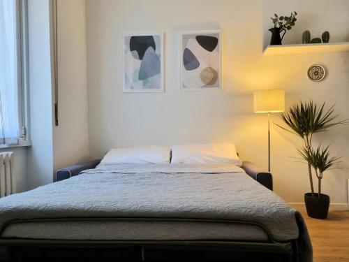 米兰Claro Apartments - Prampolini 12的一间卧室配有一张床和盆栽植物