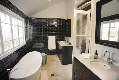 布里斯班希尔之家旅馆的带浴缸和盥洗盆的大浴室