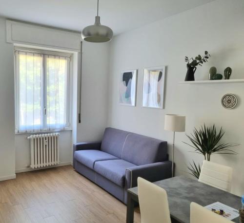 米兰Claro Apartments - Prampolini 12的客厅配有蓝色的沙发和桌子