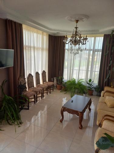 阿纳克利亚Sunrise - Guest House的客厅配有椅子、桌子和吊灯。