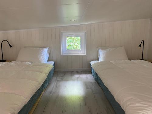 布勒萨普Kattalängan - Lilla huset的带窗户的客房内的两张床