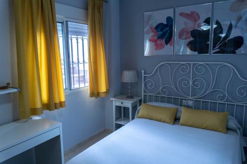 马拉加Beautiful Málaga House - Holidays的一间卧室配有白色床和黄色窗帘