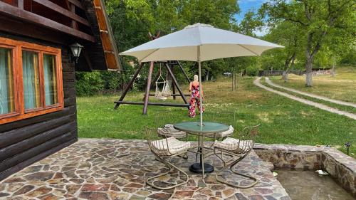 ChişcăuCabana Paulina的露台上的桌子和遮阳伞