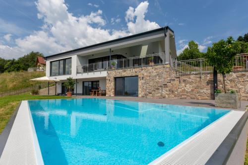 德意志兰茨贝格Greim15 --- ganzes Ferienhaus mit Fernsicht, Pool, Wellness的别墅前设有游泳池