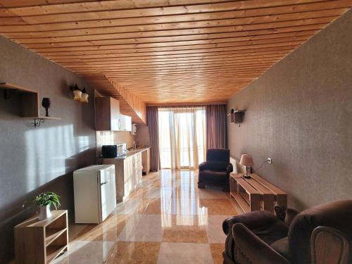 第比利斯Homelike B&B的一间带木制天花板的客厅和一间带椅子的客厅
