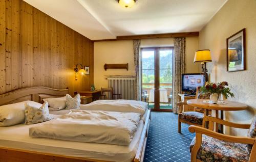 柯尼希斯湖畔舍瑙盖瑞根霍夫酒店的酒店客房设有两张床和电视。