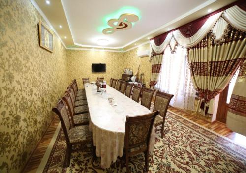 布哈拉Murod Yusufiy Boutique Hotel的一间带长桌和椅子的用餐室