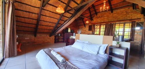 MalkernsWide Horizons Mountain Retreat的一间带一张床的卧室,位于带木制天花板的房间内