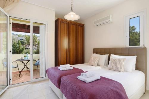 科林比亚Villa Ermis Springs by Villa Plus的一间带两张床的卧室和一个阳台