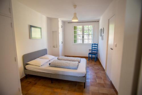 贝济耶Domaine Saint Laurent的小房间设有一张床和一张蓝色椅子