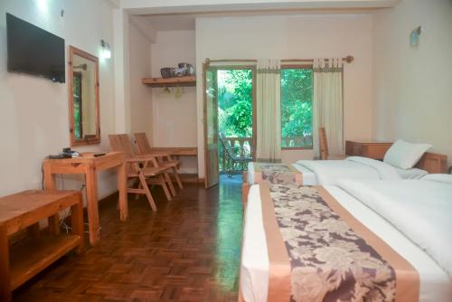 索拉哈奇旺天堂酒店的酒店客房带两张床和一张桌子以及椅子。