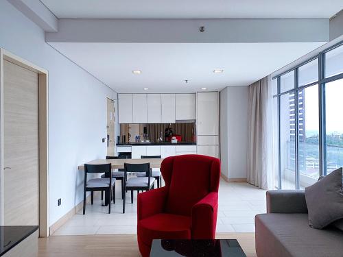 马六甲Straits Suite by C Homestay Malacca的一间带红色椅子的客厅和一间厨房