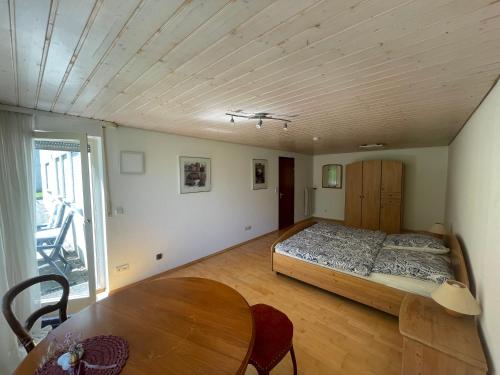 蒂宾根2-Zimmer-Nichtraucher-Ferienwohnung Strobel的一间卧室配有一张床和一张木桌