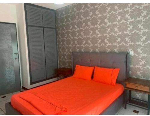 伊夫兰Bel appartement à Ifrane的卧室内的橙色床和2个橙色枕头