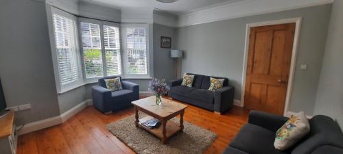曼海德Dumble Cottage的客厅配有2张蓝色的沙发和1张桌子