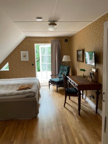卢马Bed & Breakfast Vragerups Gård的一间卧室配有一张床、一张桌子和一把椅子