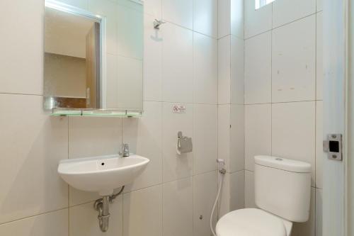 雅加达Green Apple Residence near Sarinah Mitra RedDoorz的白色的浴室设有卫生间和水槽。