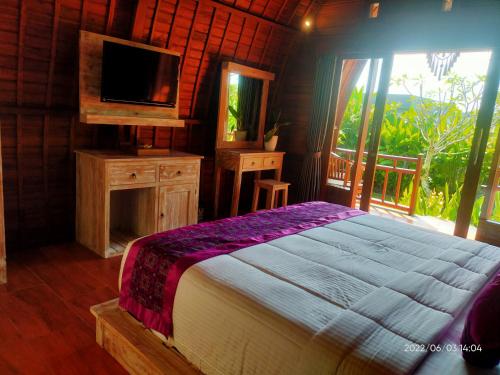 乌干沙The Jiwana Bali Resort的一间卧室设有一张床、一台电视和一个窗口。