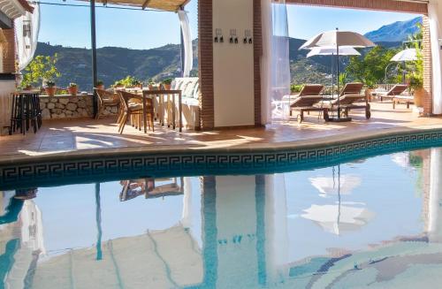 孔佩塔Malaga Hills Double Comfort Boutique & Wellness Hotel -Adults Only-的一个带椅子和桌子的游泳池以及一把遮阳伞