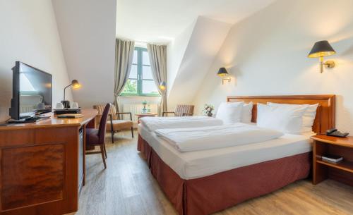 诺德施泰特奥勒霍夫酒店的酒店客房设有一张大床和一张书桌。