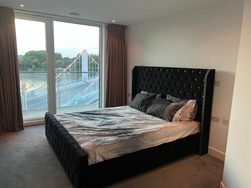 伦敦Best Location Chelsea River View /Central London的一间卧室配有一张床,享有过山车的景色