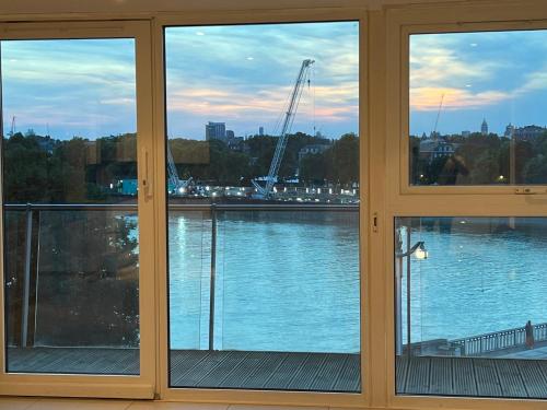 伦敦Best Location Chelsea River View /Central London的客房设有3扇窗户,享有河景