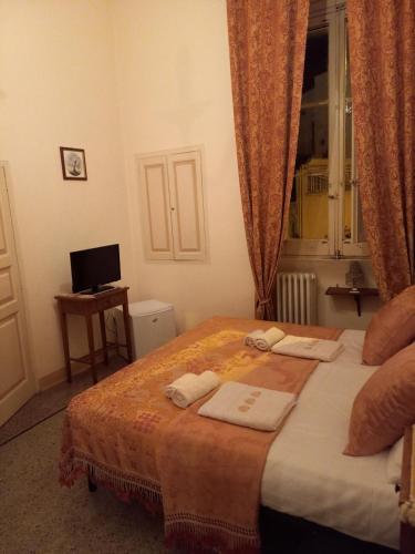 加拉蒂纳Palazzo Baffa的一间卧室配有一张床,上面有两条毛巾