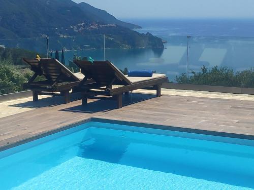 SinarádesVilla Vardia-Amazing Seaviews with heated pool的一个带两把椅子的游泳池,享有水景