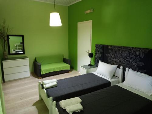 圣乔治斯Maria's Studios的绿色卧室配有两张床和椅子