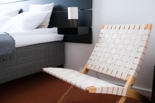 汉科Upea studioasunto historiallisella Hangon Asemalla的一张椅子,放在一个房间里的床边